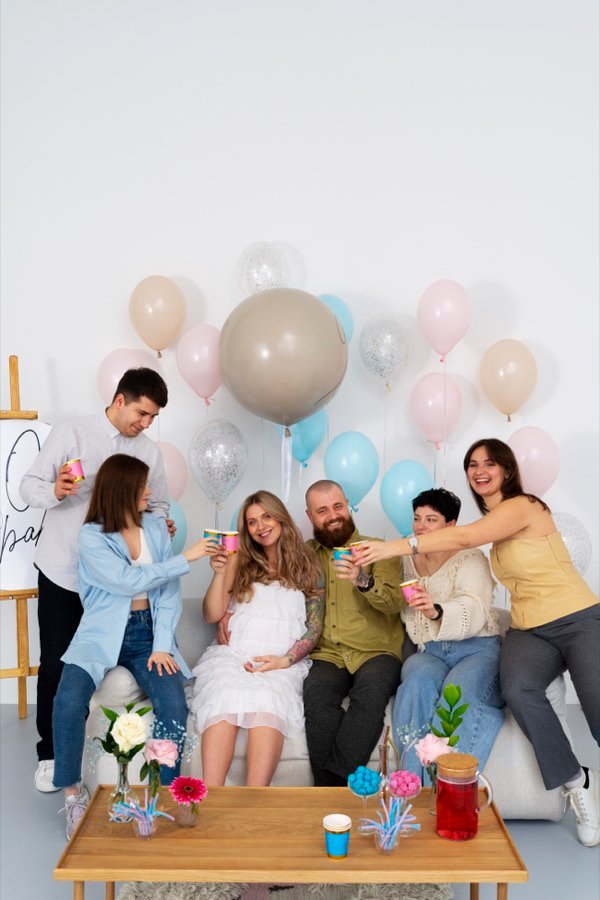 Amigos celebrando un baby shower con globos rosas y azules — inspiración para invitación digital